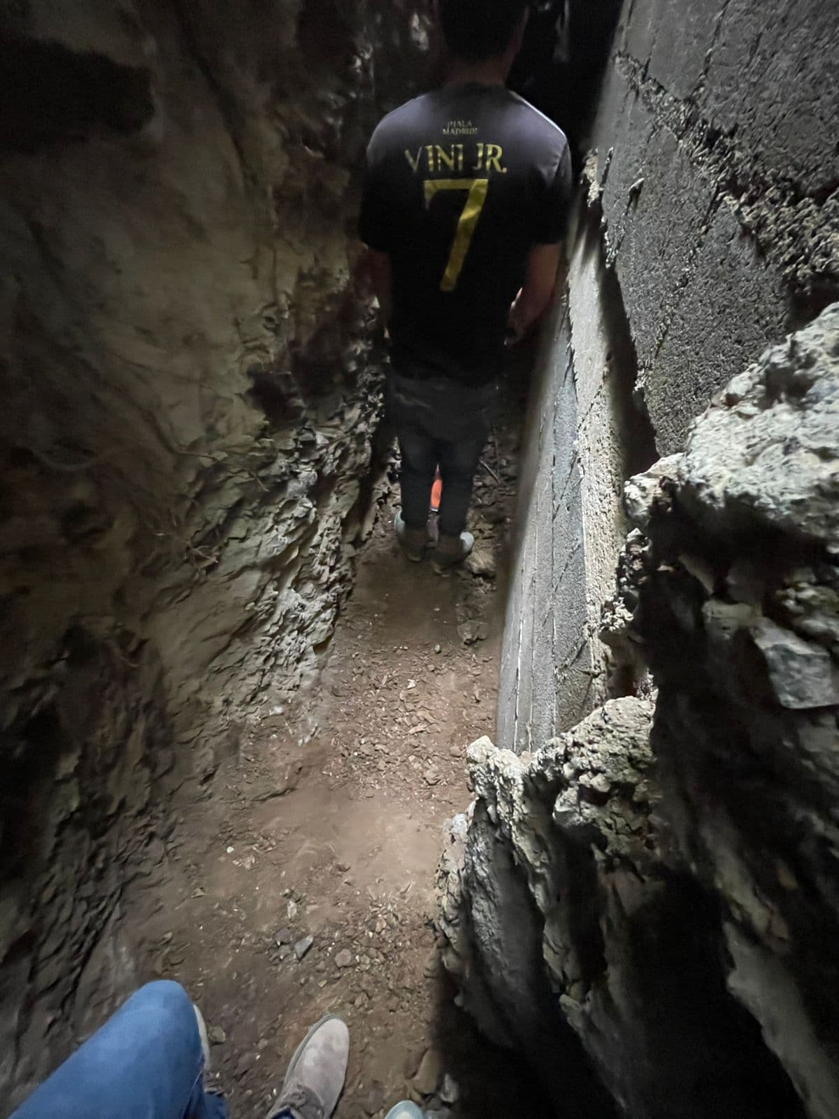 Narrow passage in a construction site with a person standing inside.