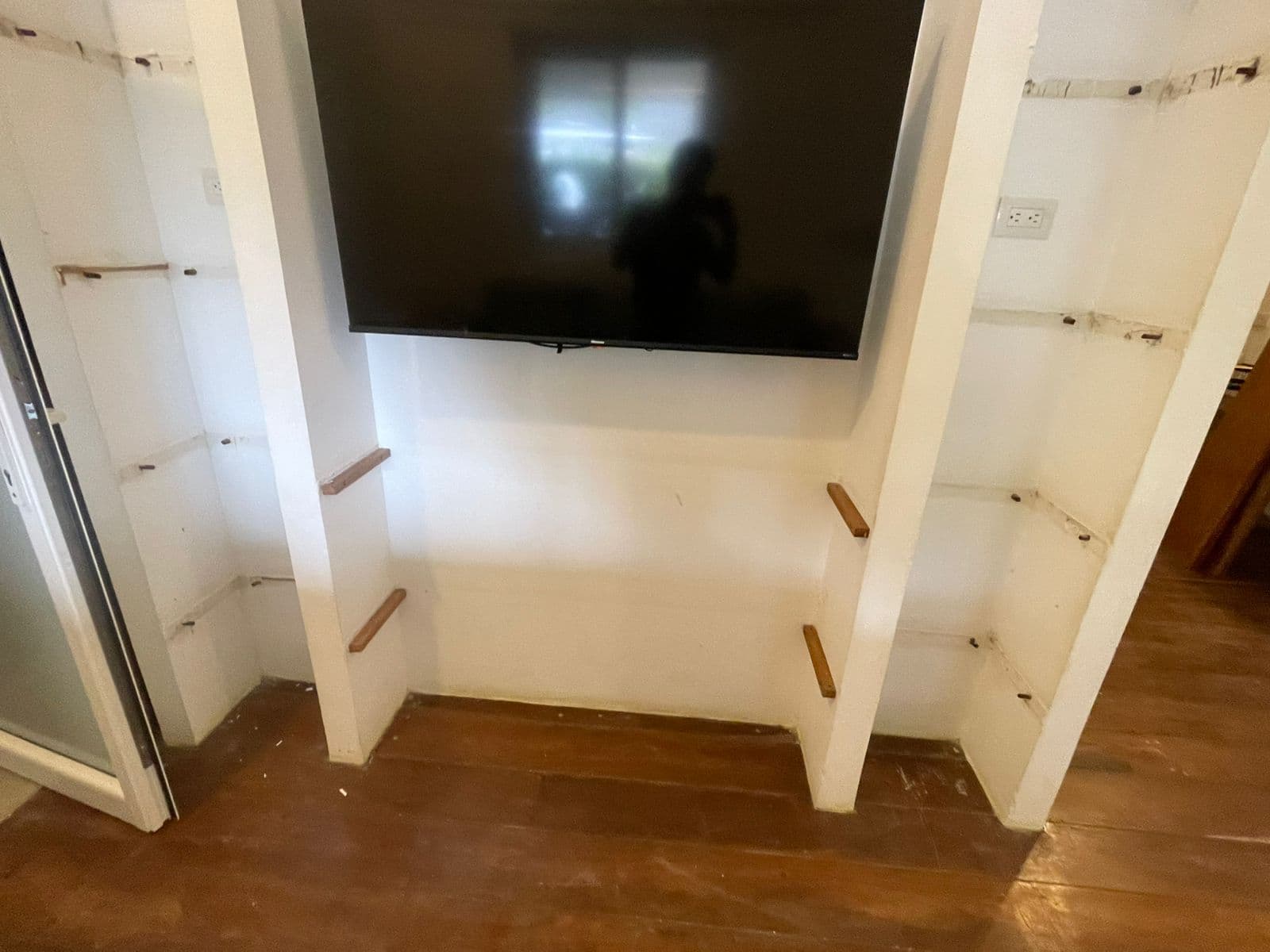 Wall-mounted TV with shelves on the sides